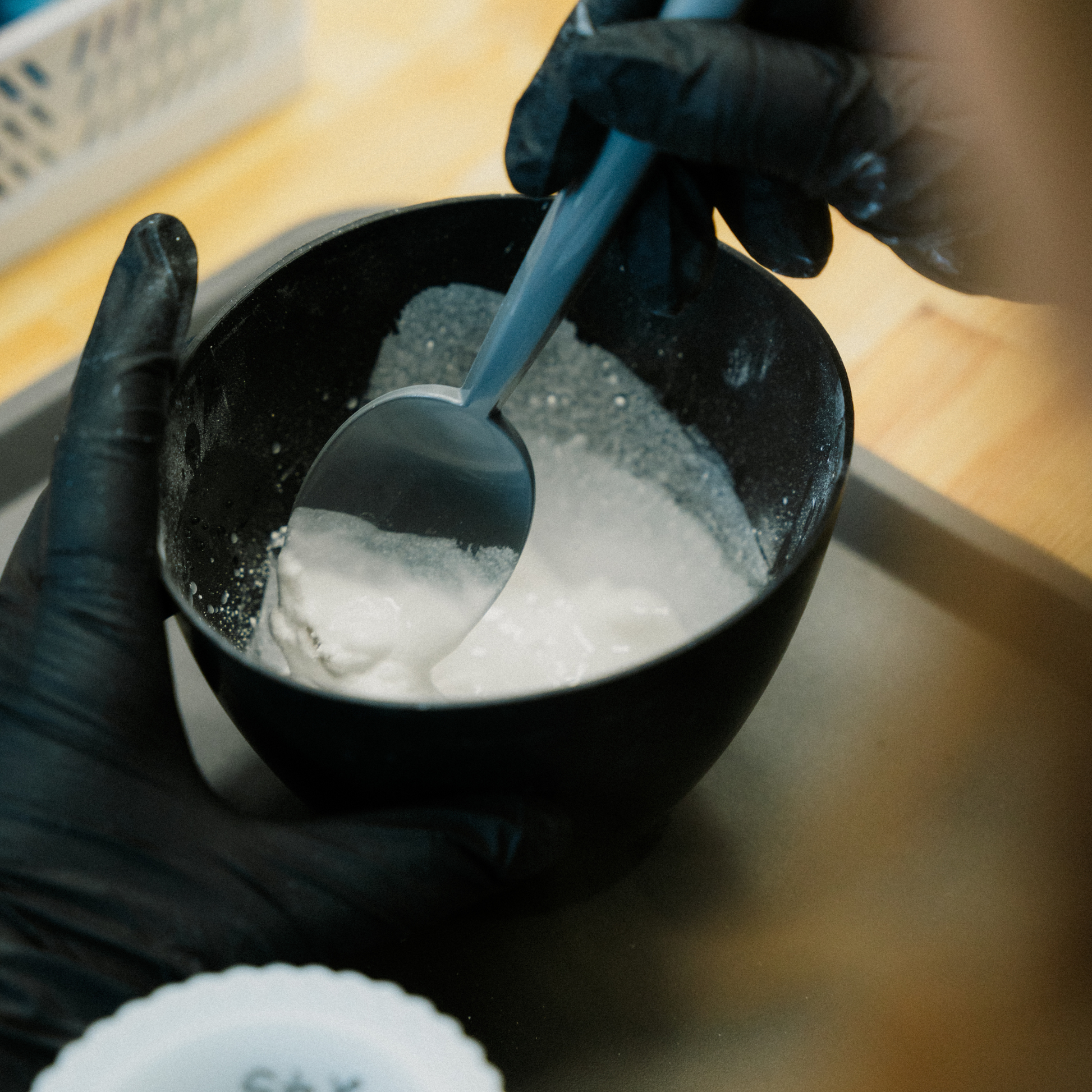 In einem Gipsbecher wird gerade von einer Person Beton zum Gießen angerührt.