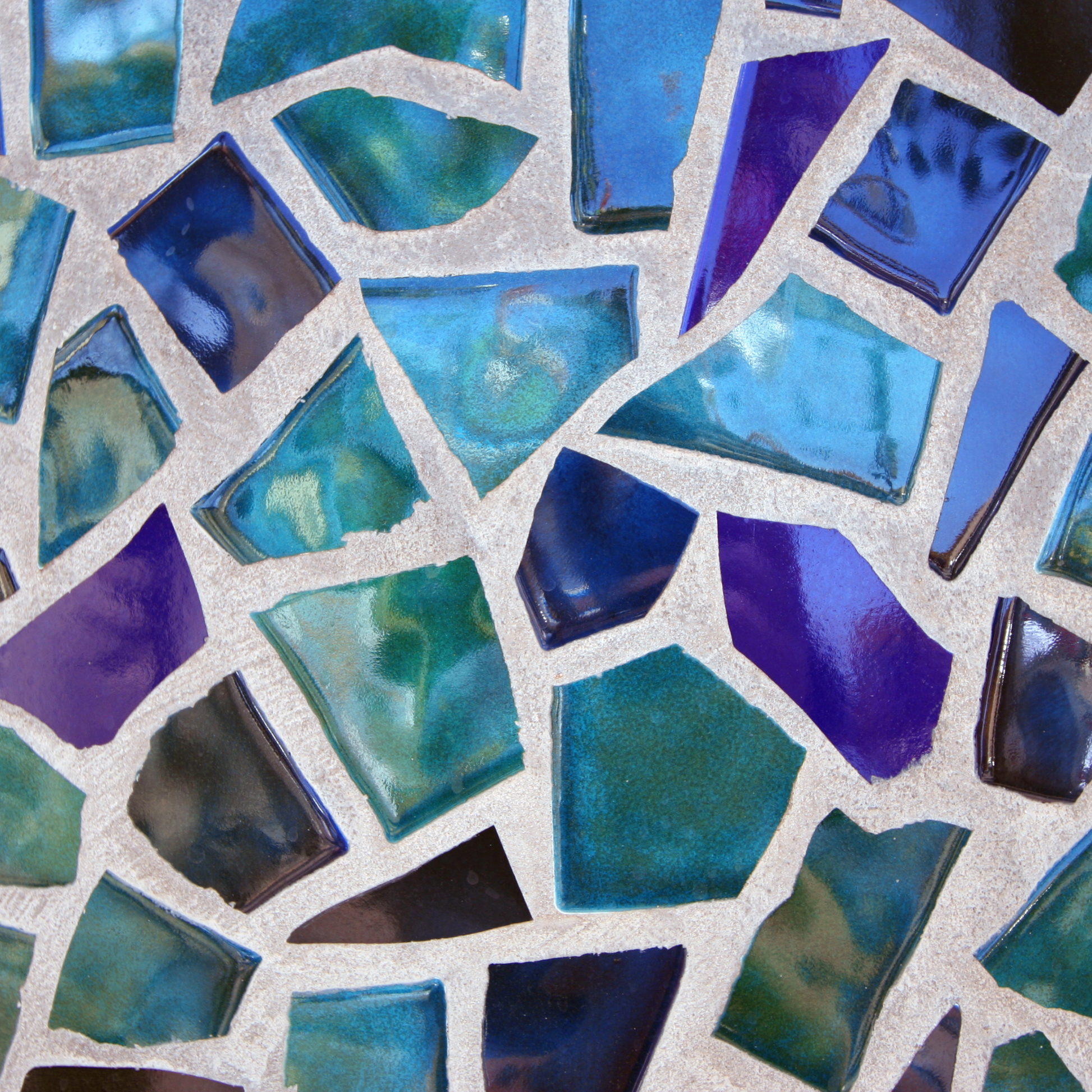 Mosaiksteine aus Glas eingearbeitet in Beton, schillernd in verschiedenen Farben.