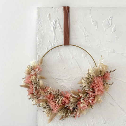 Blumenring aus einem dünnen Drahtgestell mit roten und beigen Trockenblumen und braunen Aufhänger