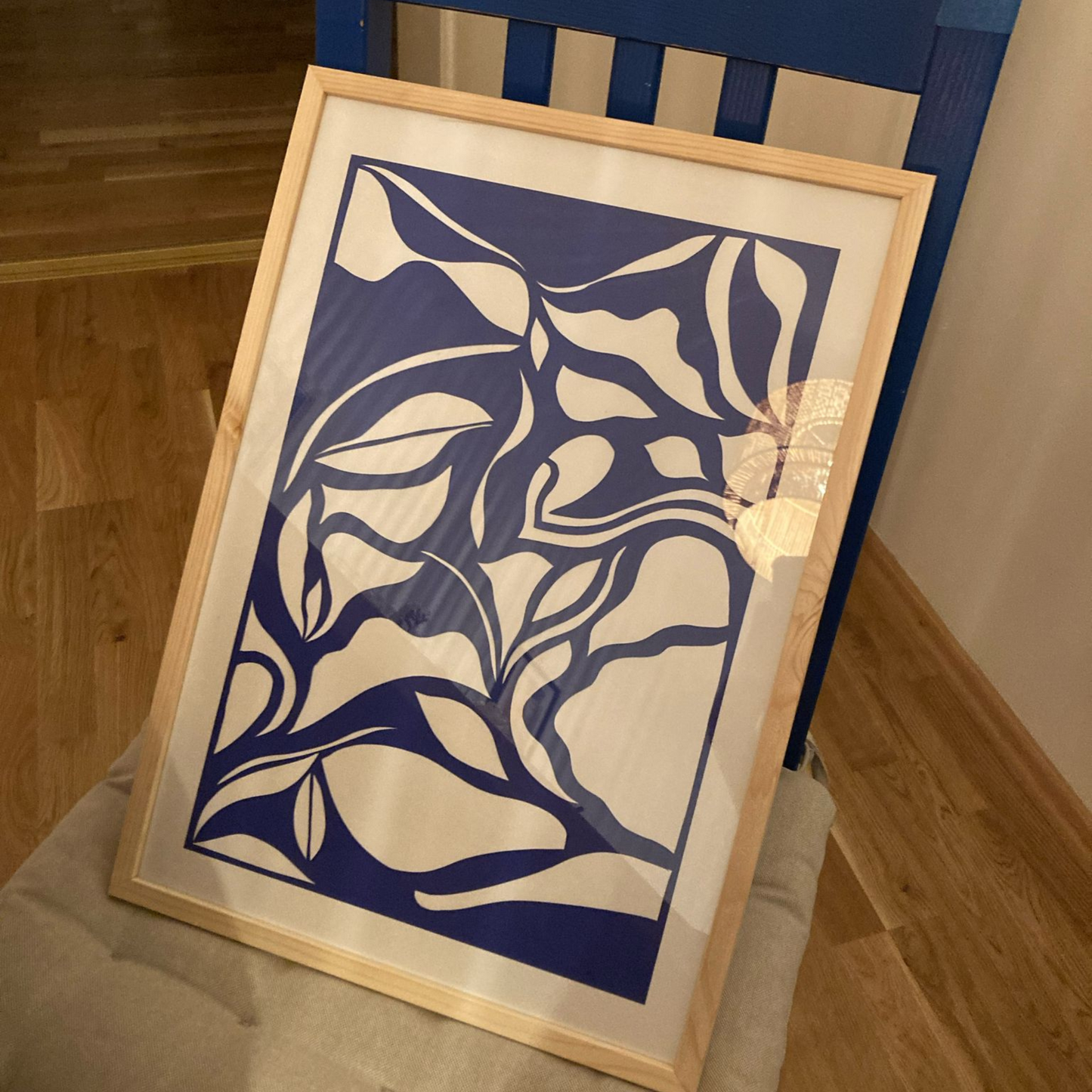 Ein Bild auf einem Stuhl stehend in Holzrahmen im Workshop papercut erstellt.