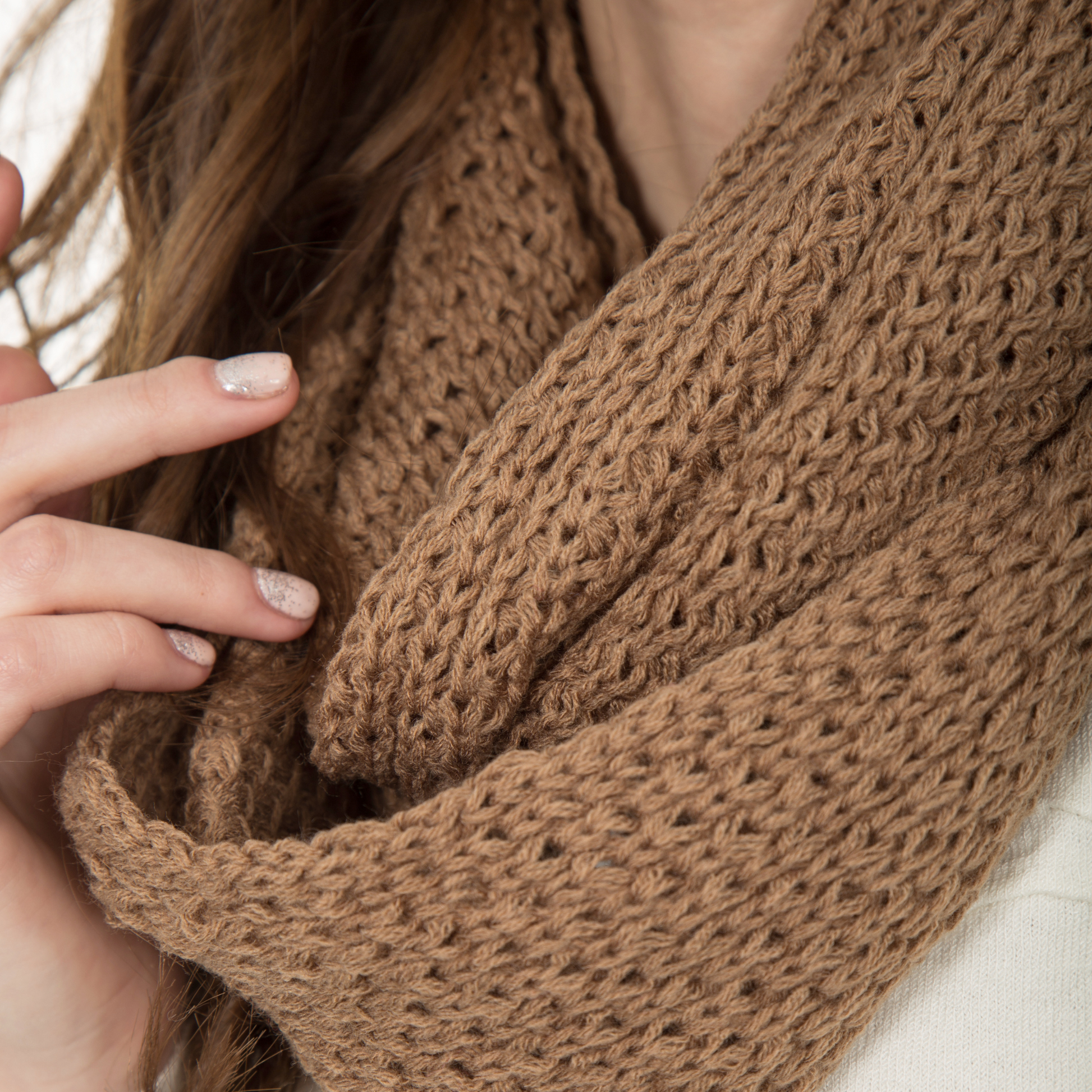 Frau mit einem selbst gestrickten braunen Schal im den Hals